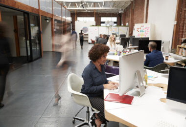 Business Team Working At Desks In Modern Open Plan Office